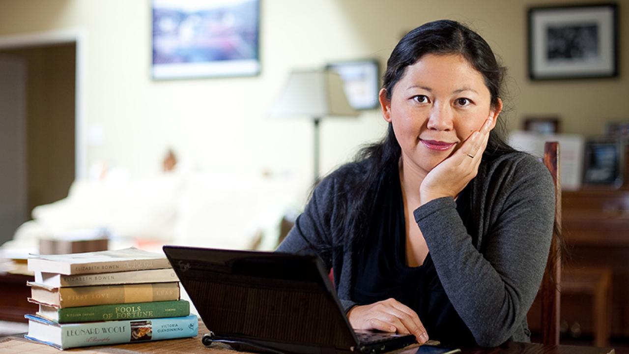Photo: Yiyun Li at laptop computer, resting chin in hand