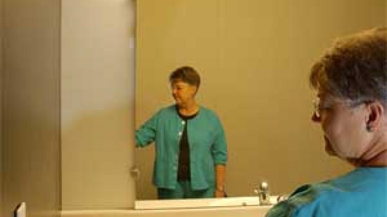 Photo: woman going to touch light switch in bathroom