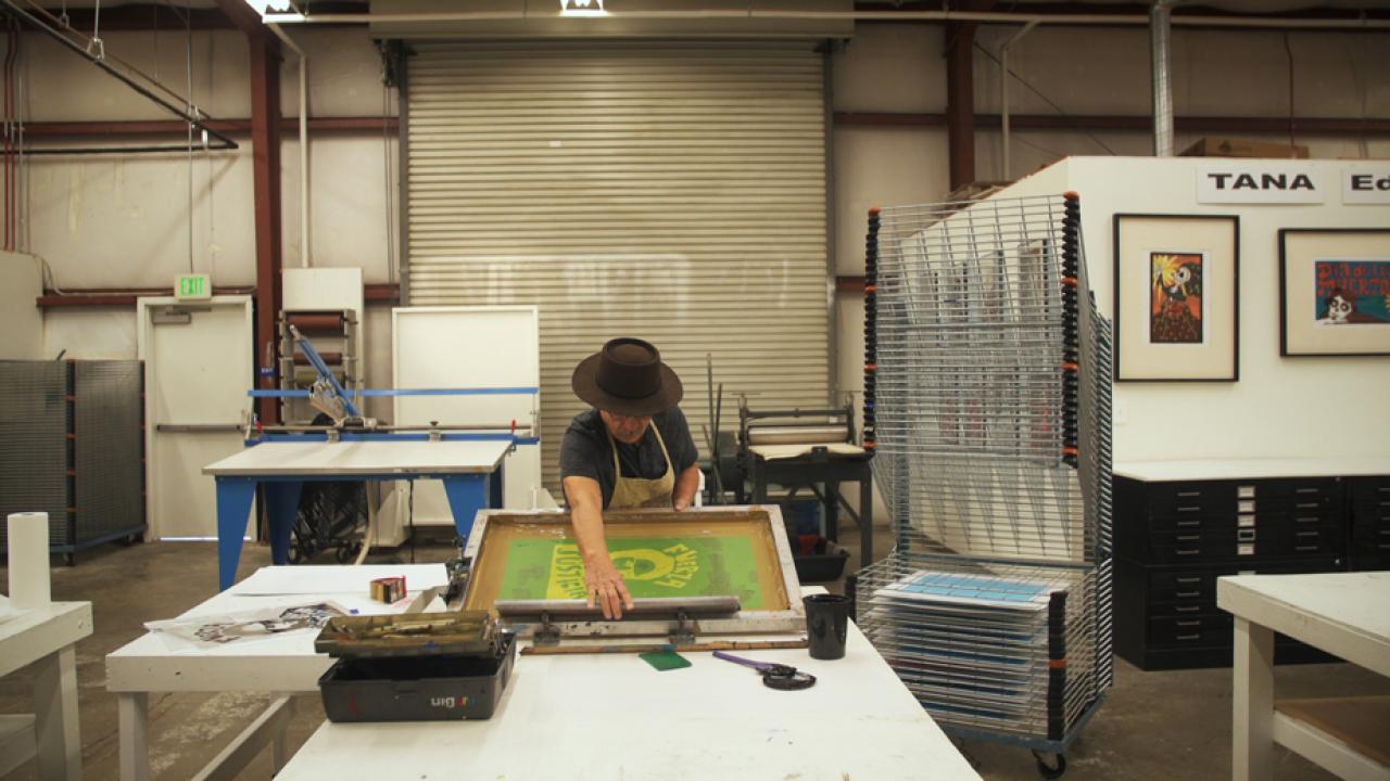 Photo: Malaquias Montoya, making a silkscreen print.