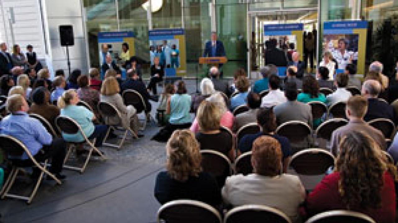 Chancellor Larry Vanderhoef, above middle, and Claire Pomeroy, far right, vice chancellor for human health sciences and dean of the medical school, look on as Ed Penhoet, president of the Gordon and Betty Moore Foundation, announces the $100 mil