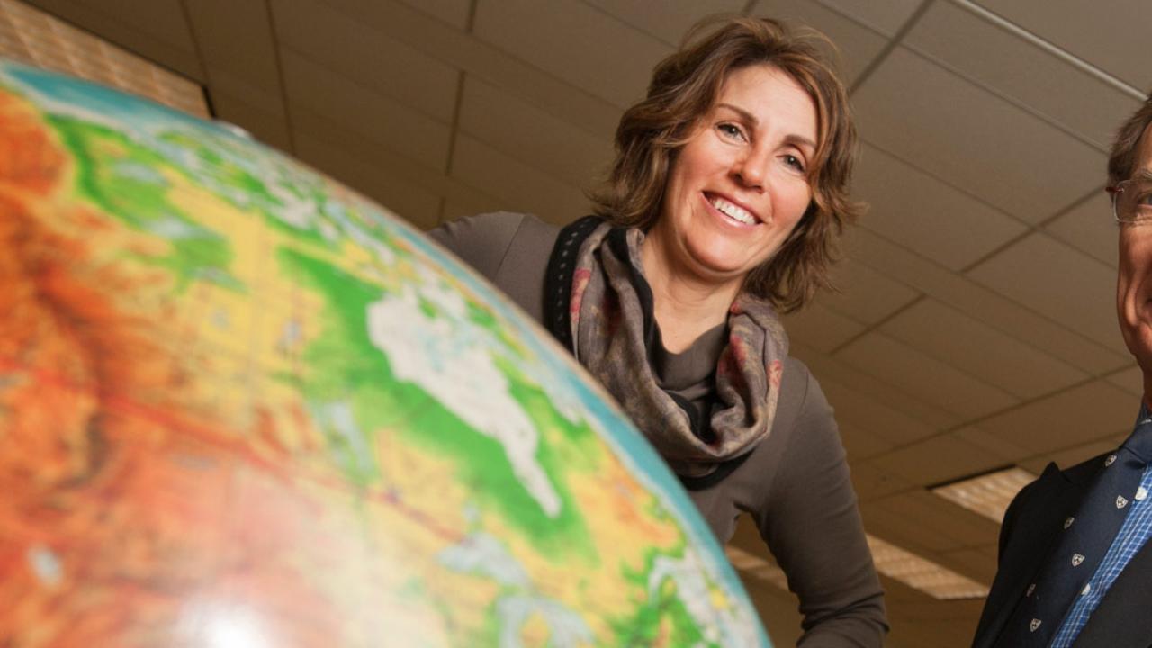 Amy Myers Jaffe, left, and Paul A. Griffin behind a big world globe