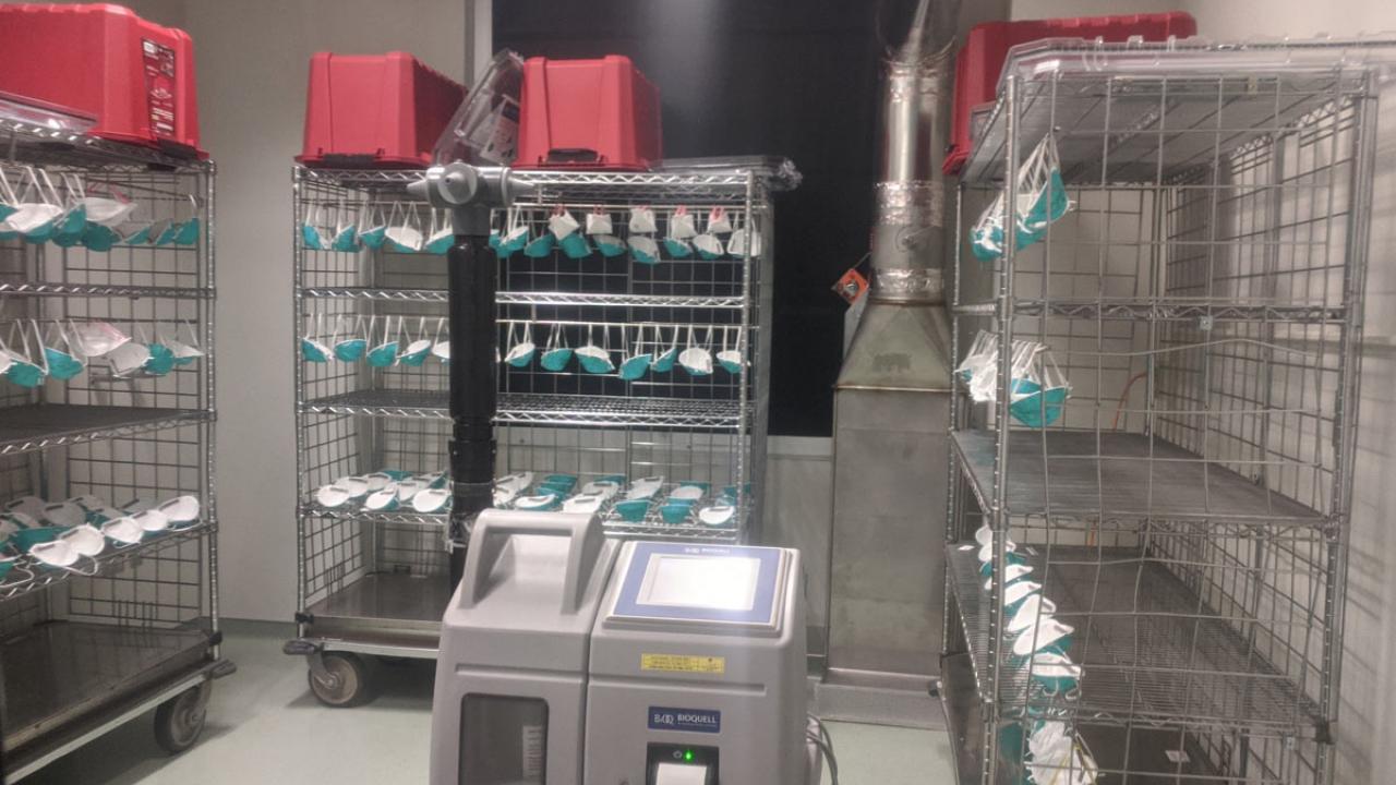 N95 respirator masks hang on racks in decontamination chamber.