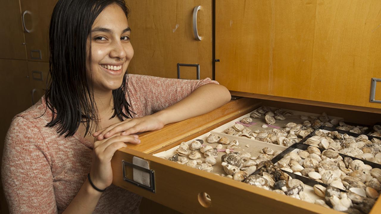 Photo: Natalia Lopez Carranza stands next to open specimen drawer.