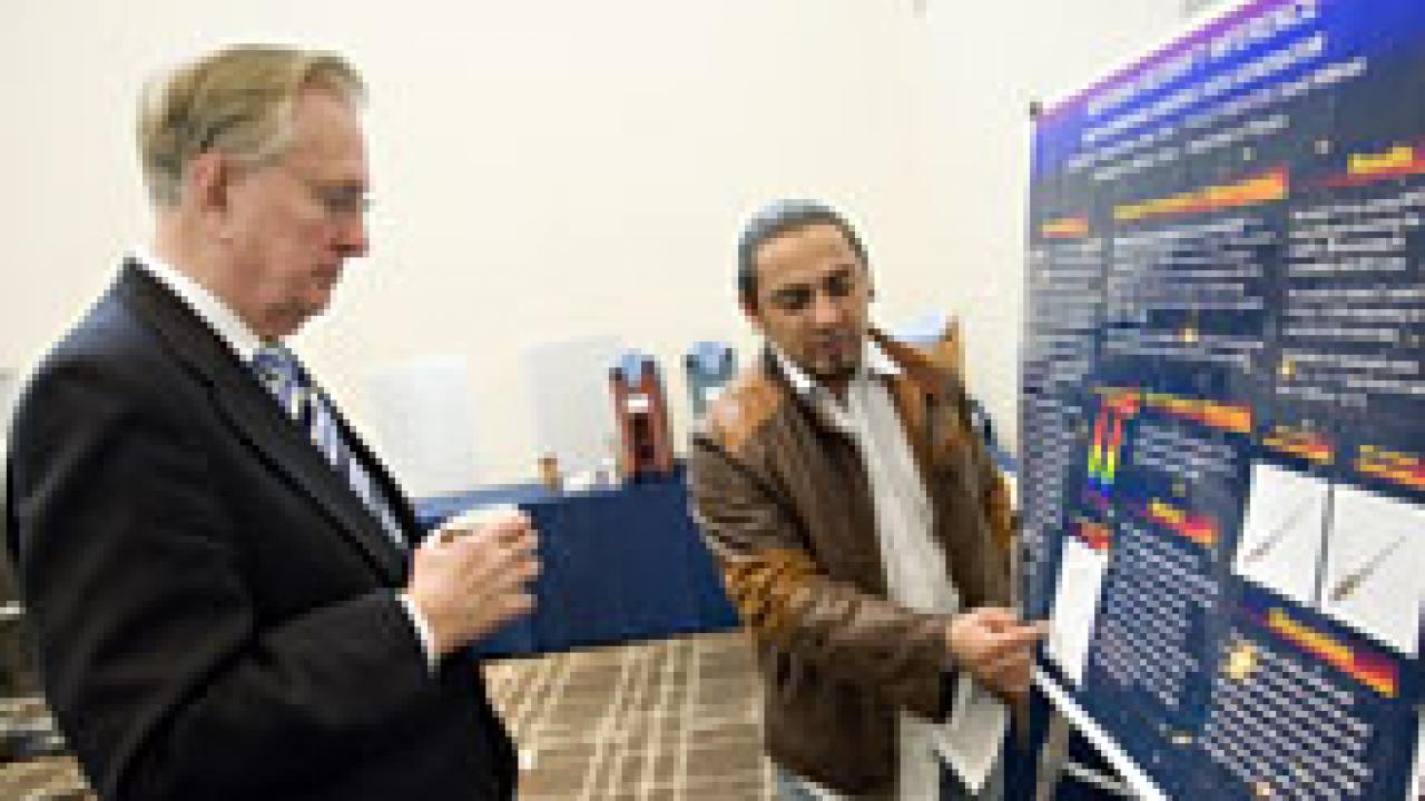 National Science Foundation Director Arden Bement, left, looks at the research work of UC Davis student Marcos Torres after Bement spoke March 5 about science and innovation.