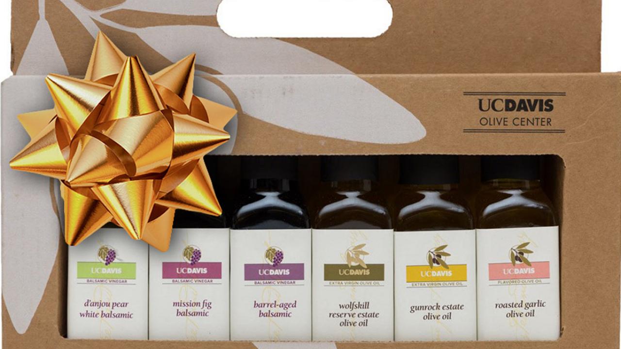 Six-bottle gift box of olive oils and vinegars, with gold bow.