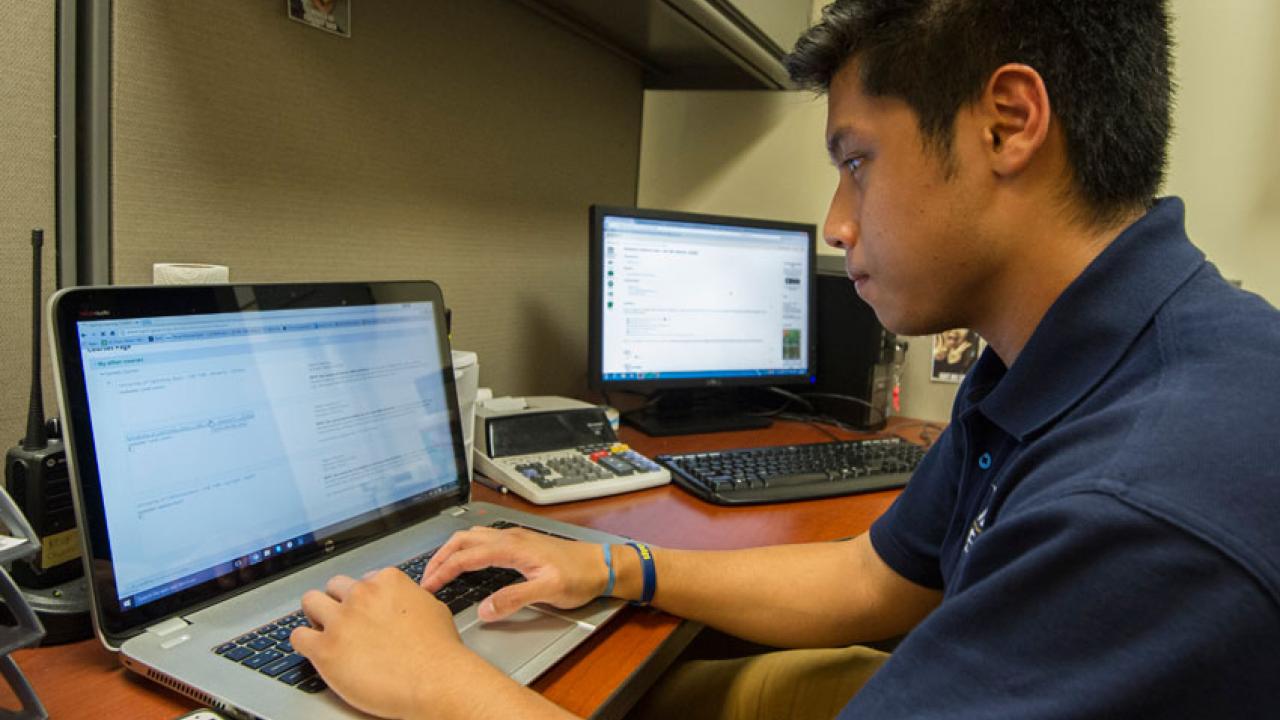 Photo: Student Patrick Khamnrongsad works on laptop, with Inclusive Access digital course content