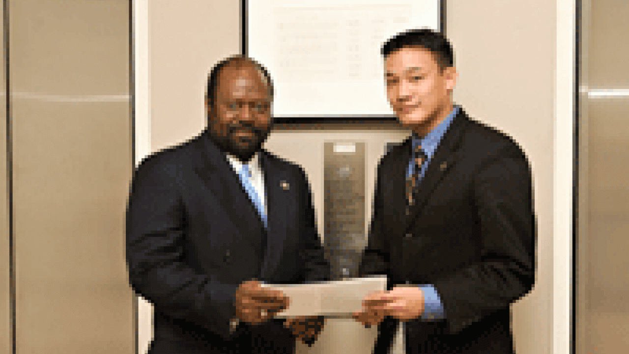 Associate Executive Vice Chancellor Rahim Reed, left, and student Steven Lee discuss the final draft of the Principles of One Community. The document is separate from the campus&rsquo;s Principles of Community, seen on the wall behind the men. It wa