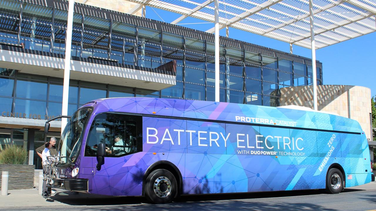 A purple and blue bus reads: Proterra Catalyst battery electric.