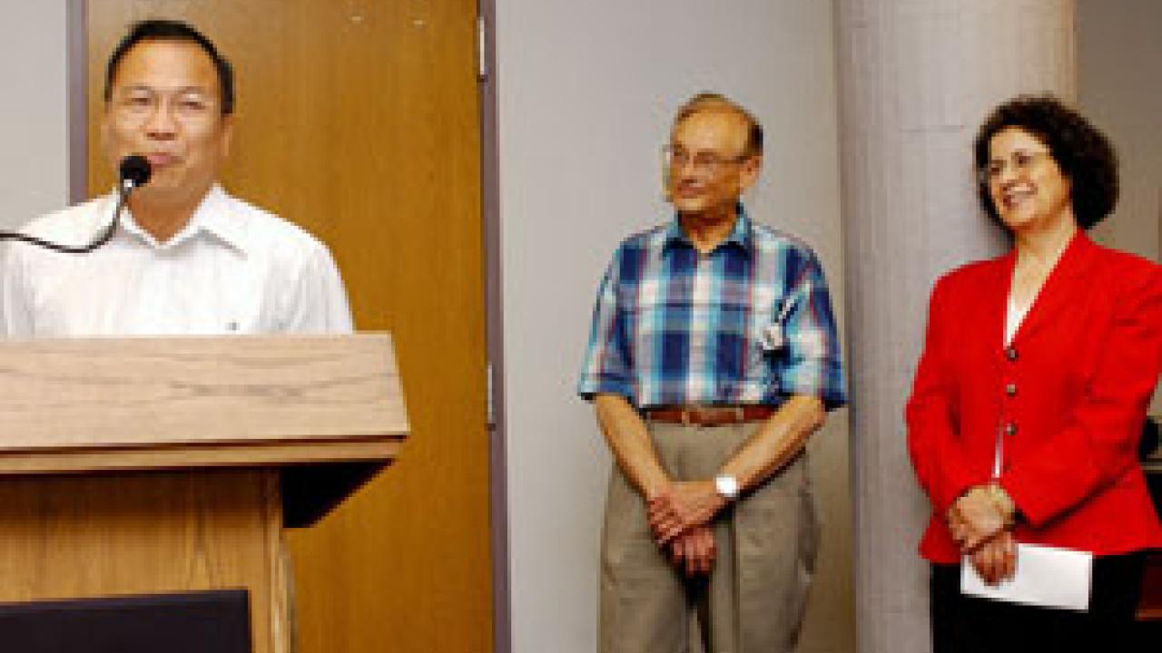 Wing Thye Woo offers comments during the senate meeting as fellow 2004 public service awardees Howard Schutz and Suad Joseph look on.