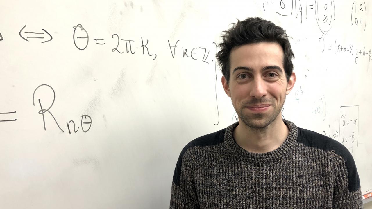 Mathematician Roger Casals in front of a whiteboard.