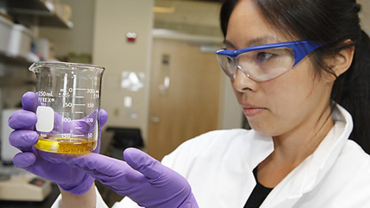 Photo: Selina Wang, Olive Center research director, holding a beaker