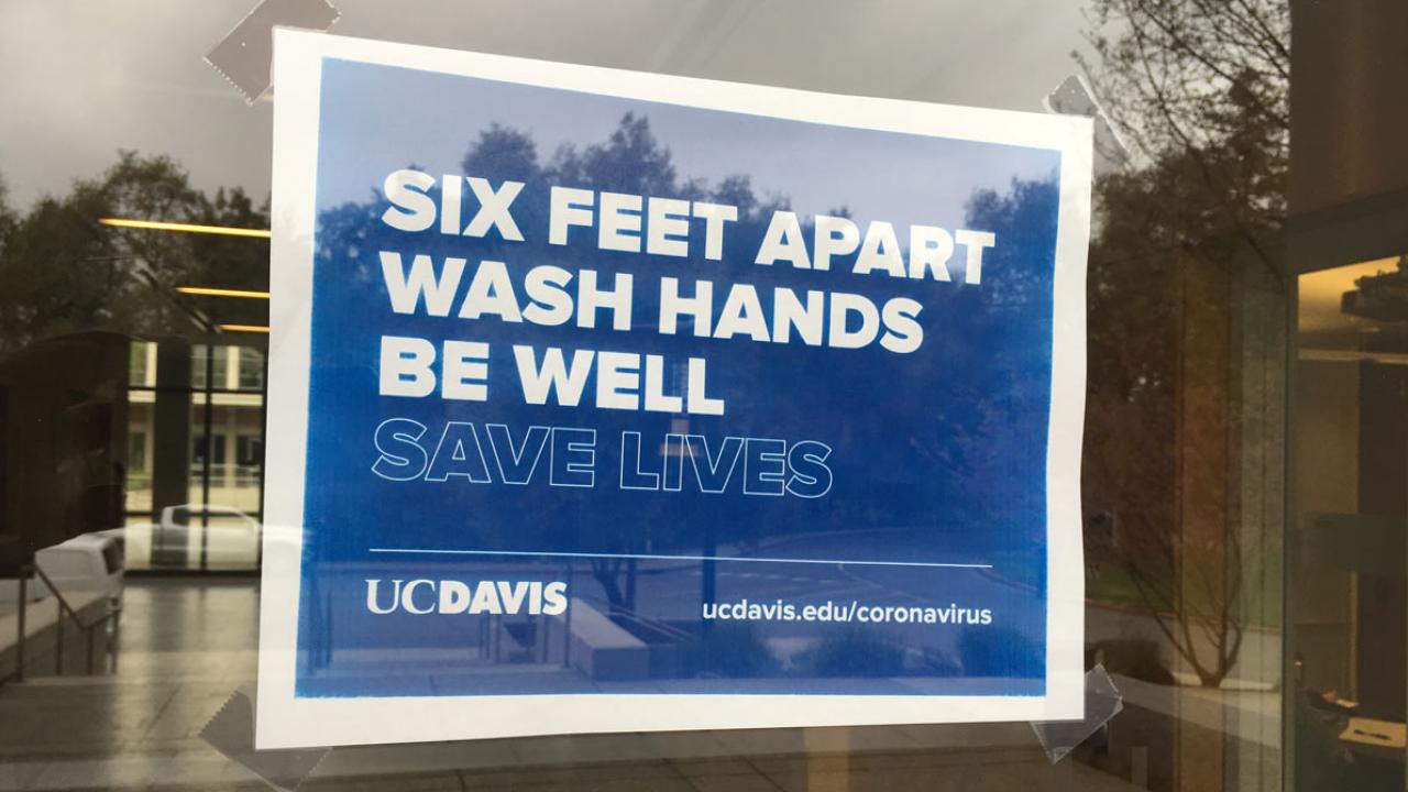 Sign on door: "Six Feet Apart. Wash Hands. Be Well. Save Lives."