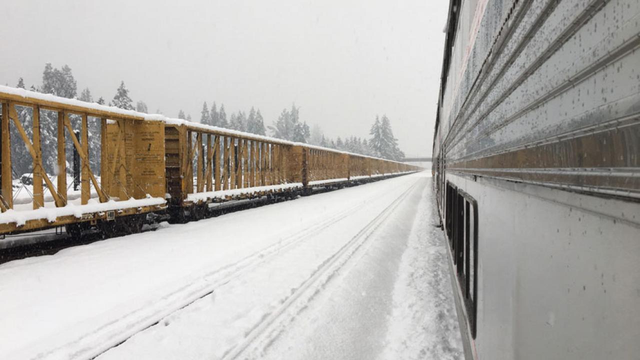 View of freight cars, from Amtrak train stranded in the snow