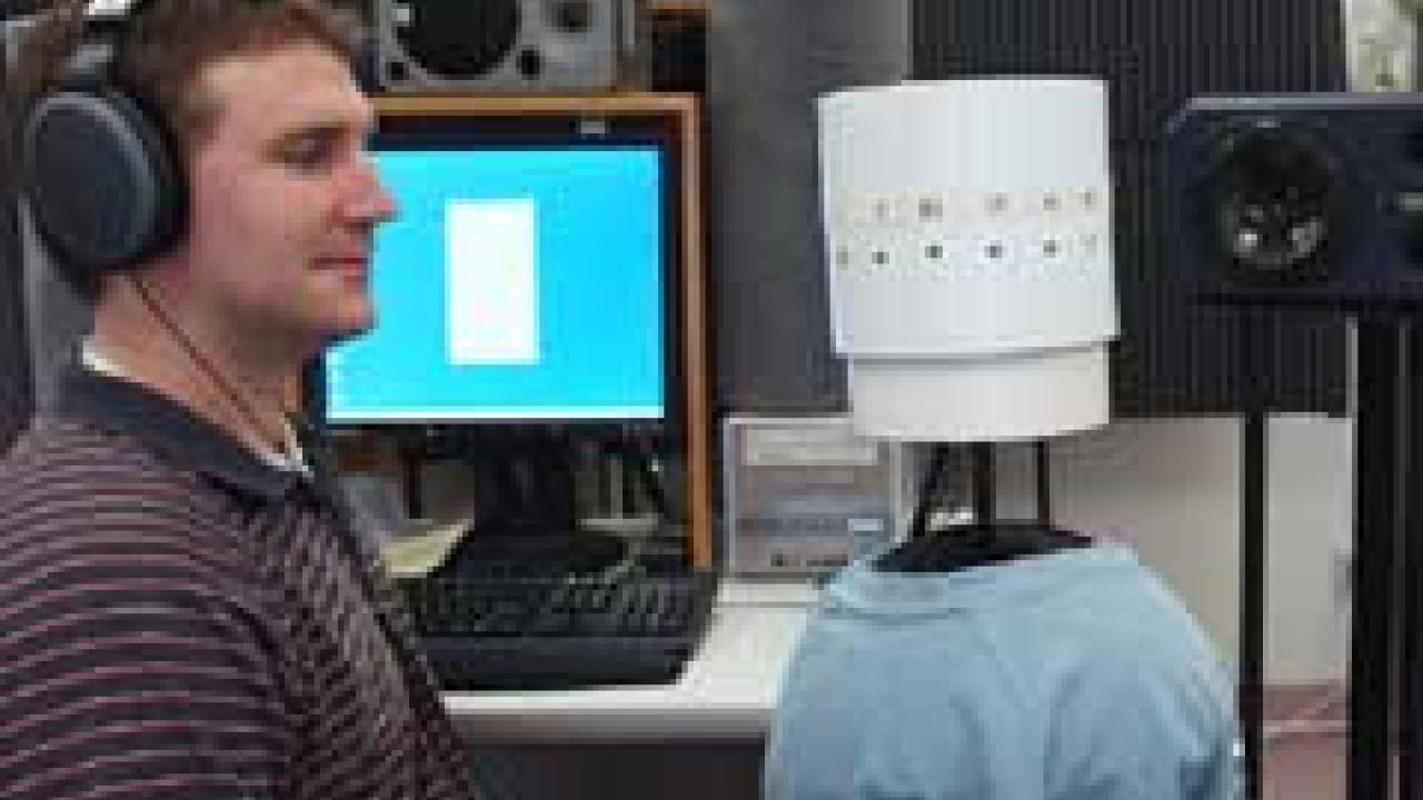 Photo: man staring at cylinder with equipment in background