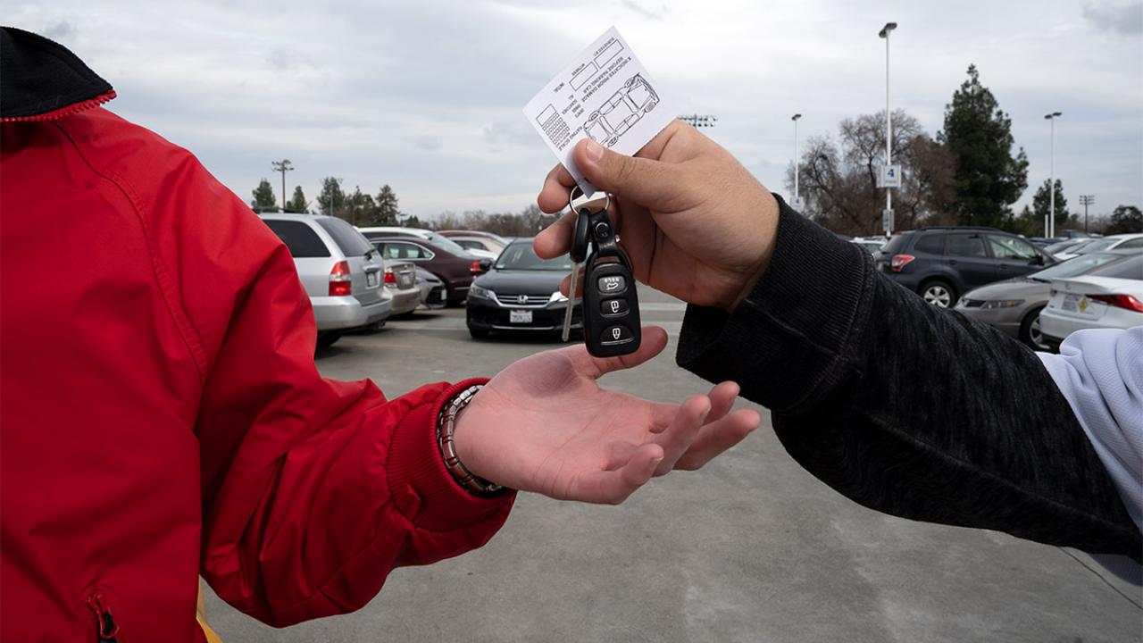 A driver hands off keys to an attendant.