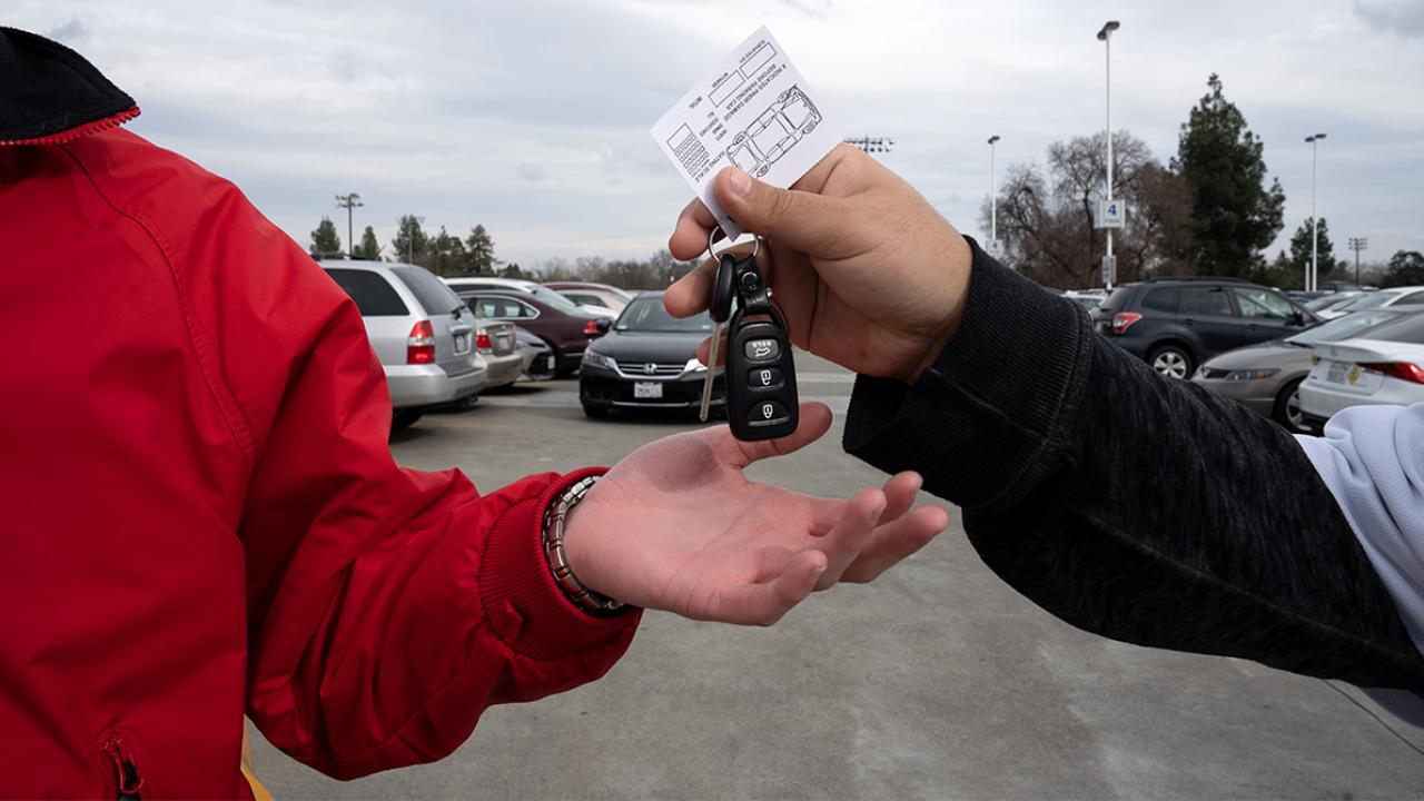 A driver hands off keys to an attendant.