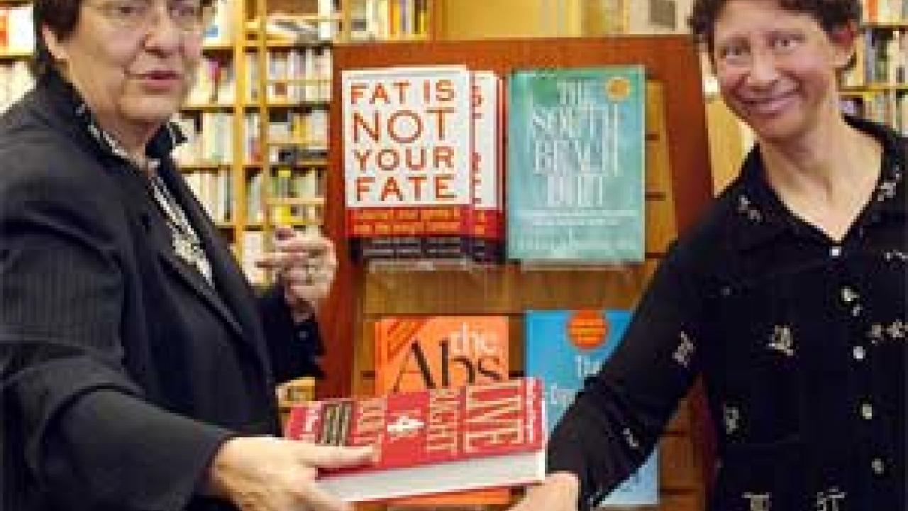 Photo: two women holding diet books