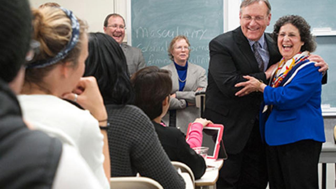 Photo: Dean George R. Mangun embraces the teaching prize recipient, Professor Suad Joseph, in her classroom.