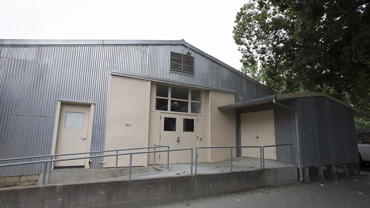 Low, one-storied metal building with cement ramp leading to doors.