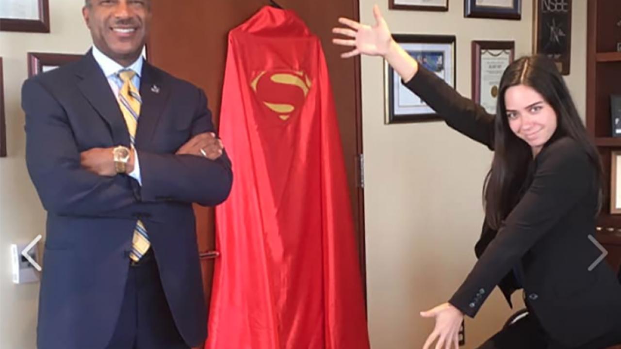 Chancellor Gary S. May and Teddy Cruz beside a hero cape