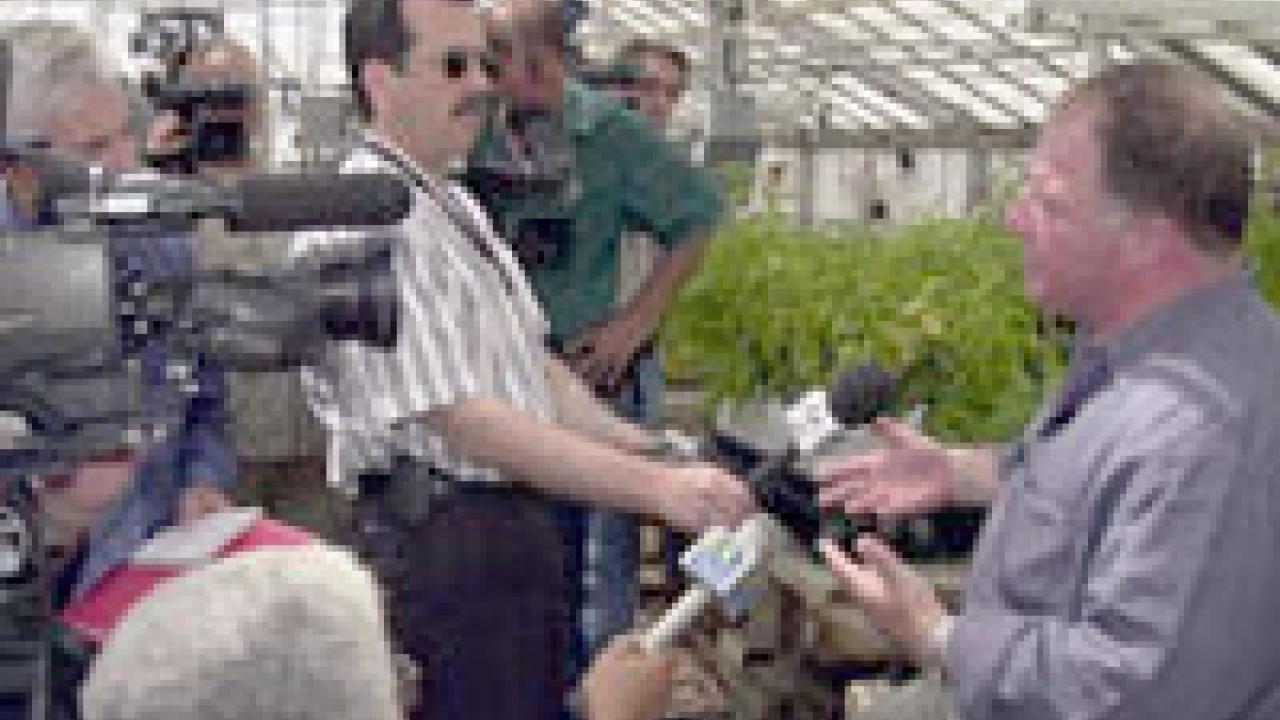 photo of man being interviewed by television reporters with cameras