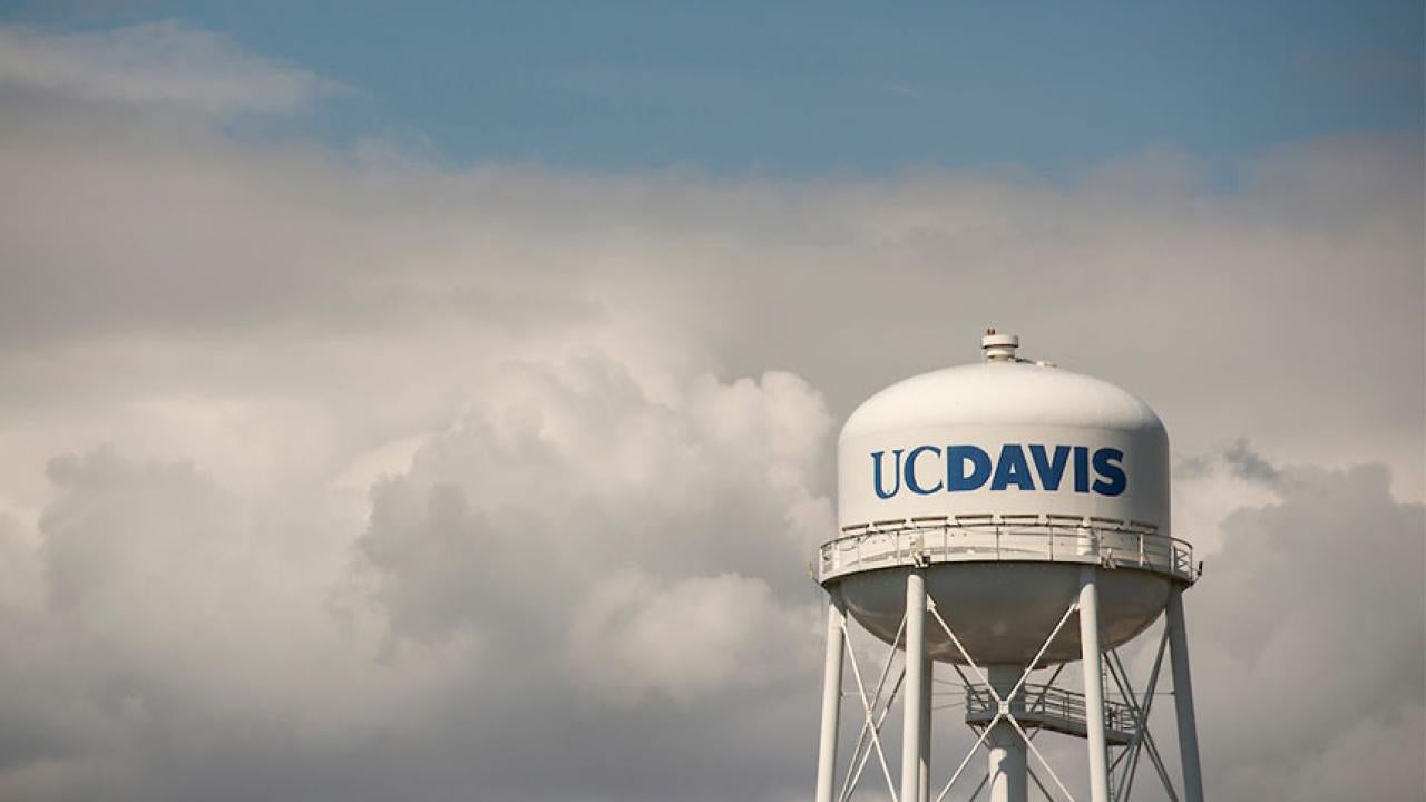 UC Davis tower against blue sky and clouds