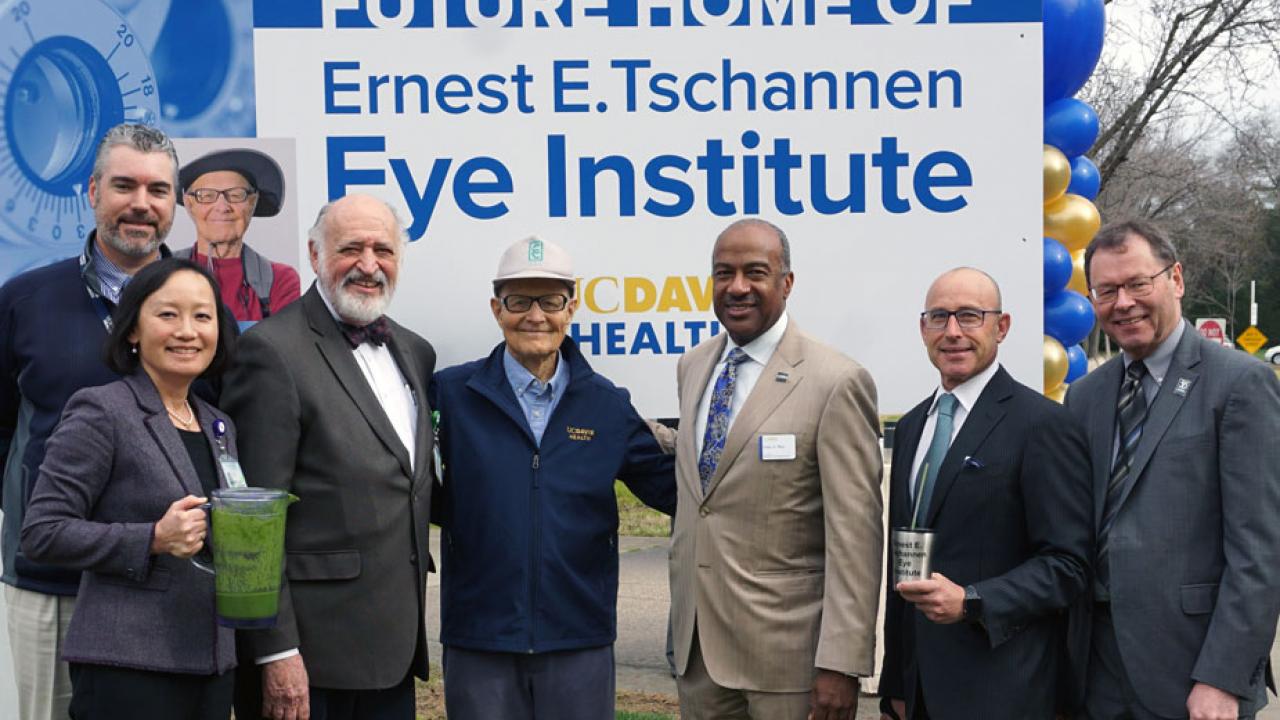 Executives and donor pose in front of sign announcing the "Future Home of Ernest E. Tschannen Eye Institute" at UC Davis Health.