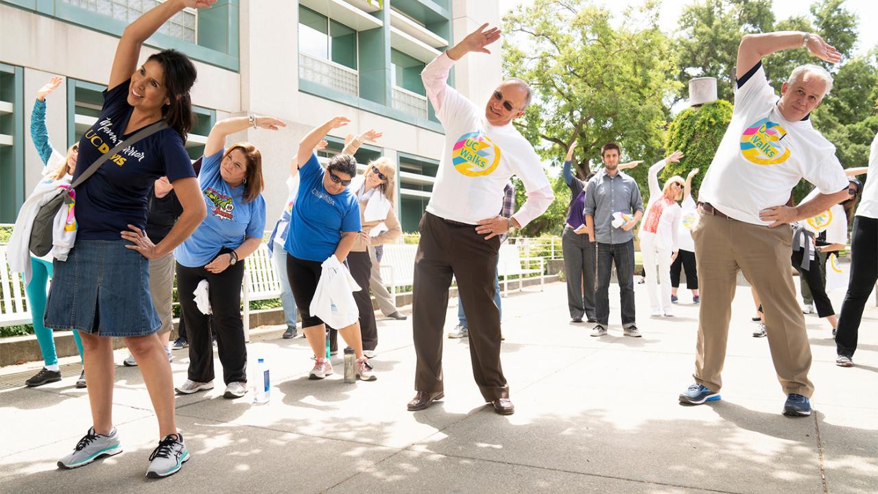 Provost Ralph J. Hexter and others stretch before a UC Walks event at UC Davis.