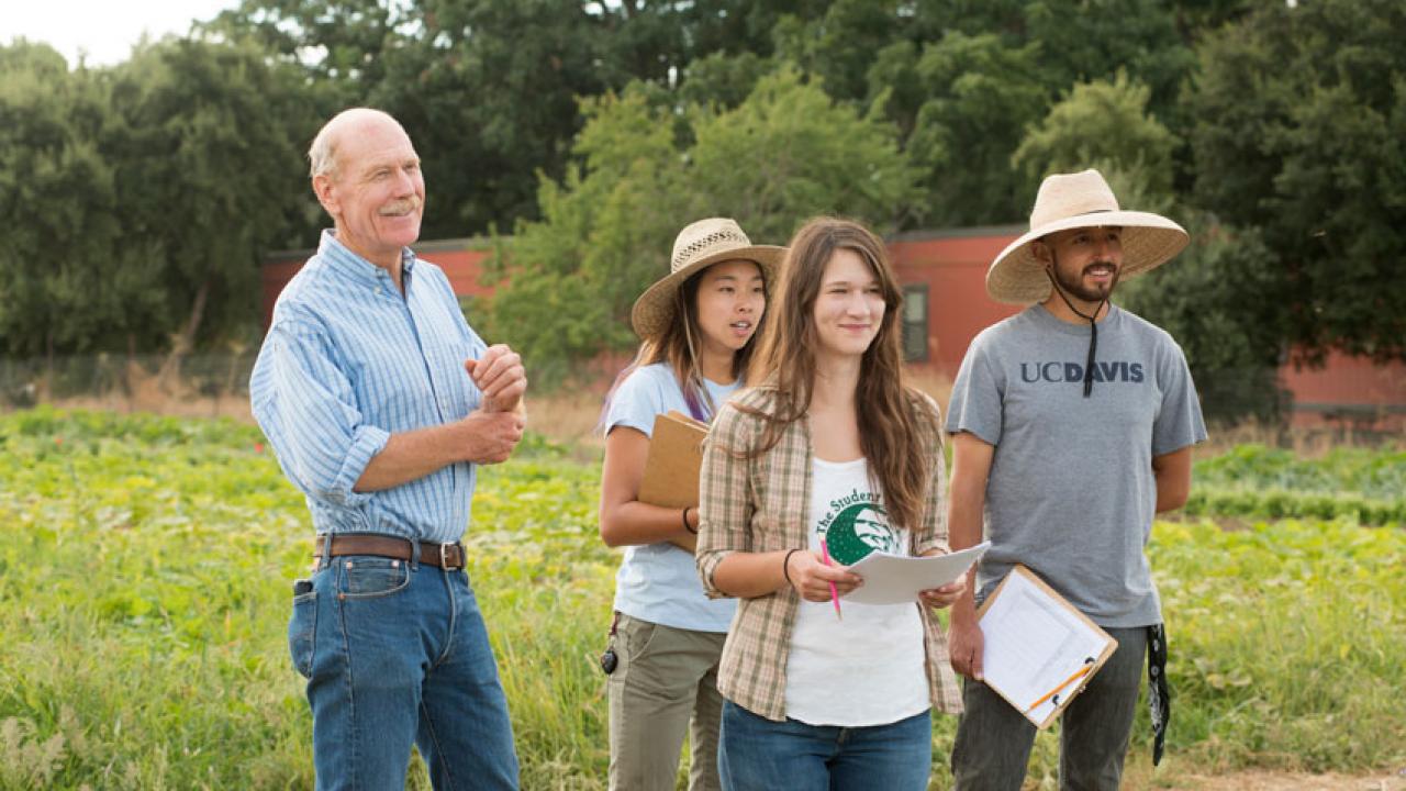 Photo: Smiling Mark Van Horn with three students at the farm.
