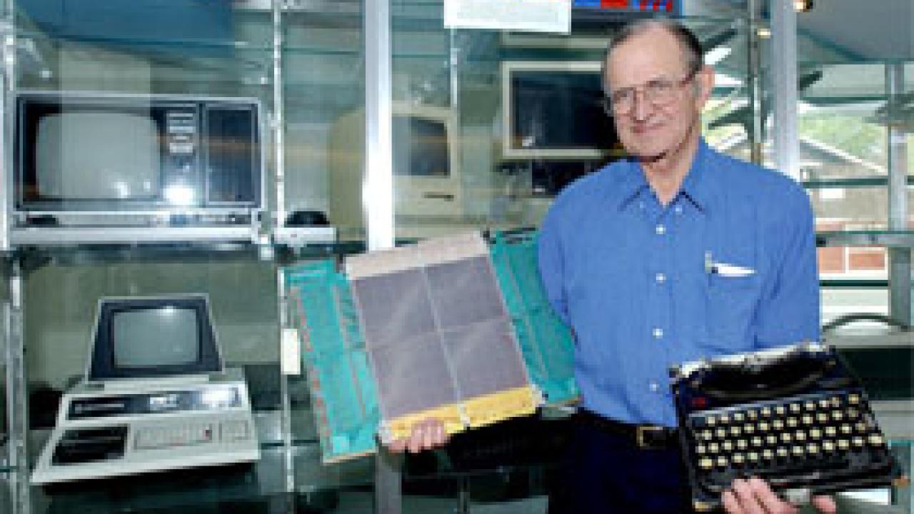 Dick Walters shows off some relics of campus computing days-gone-by &mdash; part of a collection displayed in Kemper Hall. The emeriti professor is shown holding a memory board from the Burroughs B6800 from campus use and the 1922 Remington typewrit