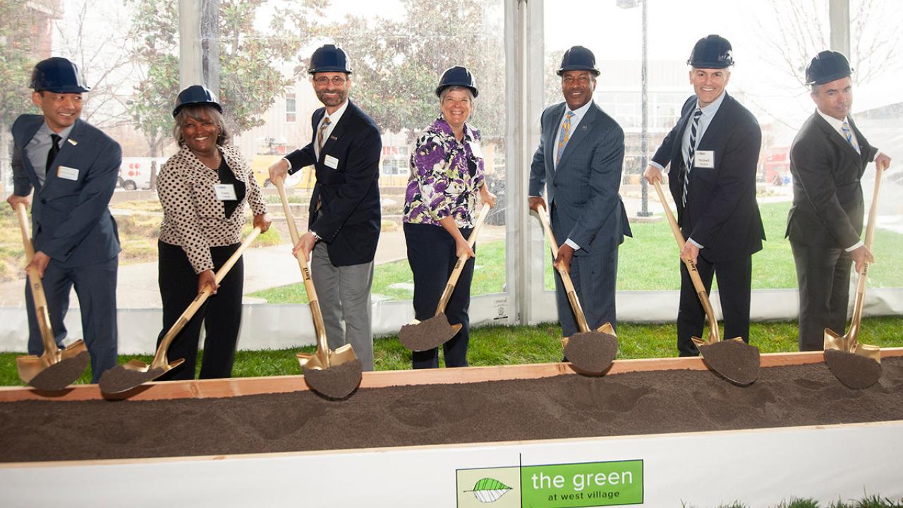 Officials from UC Davis shovel dirt during groundbreaking ceremony.