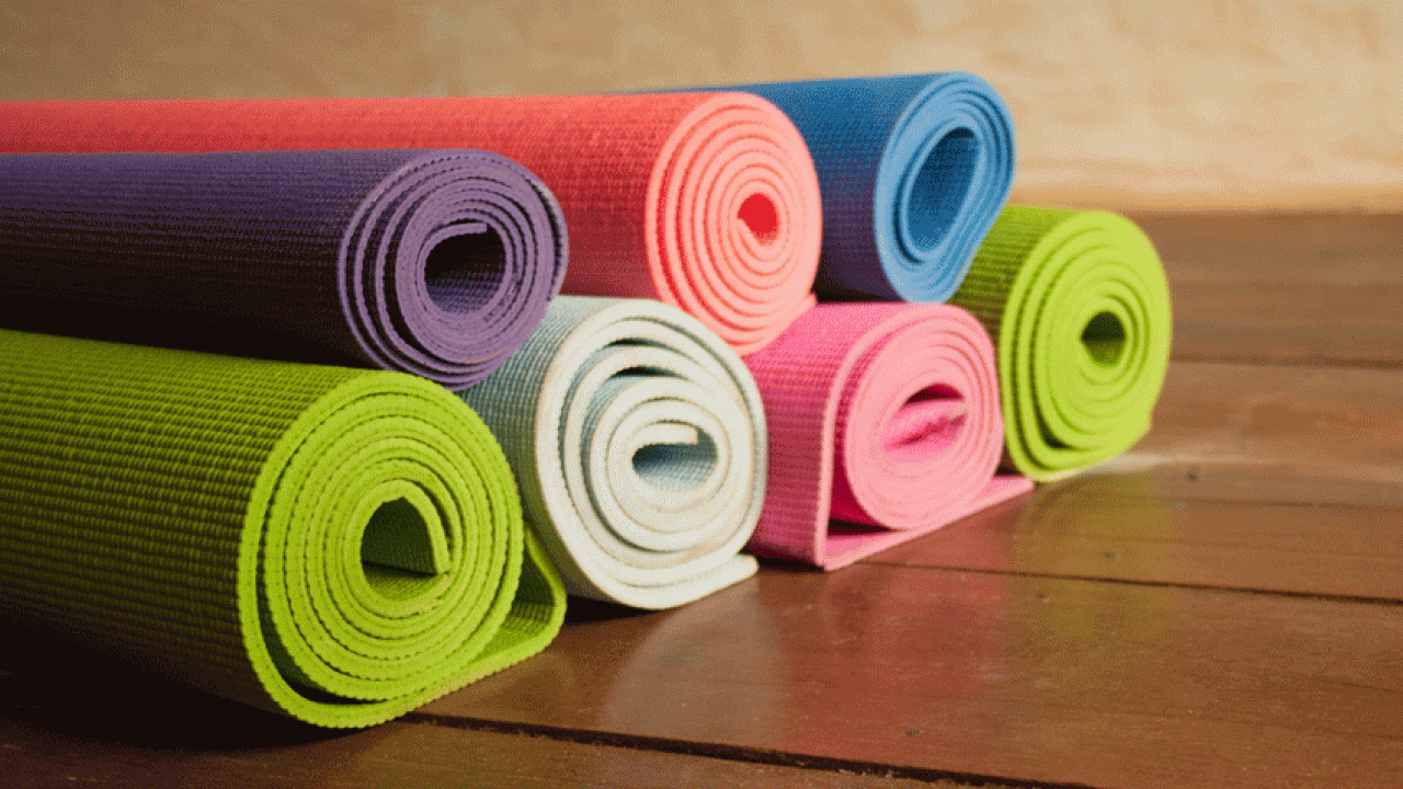 Seven yoga mats, rolled up and stacked