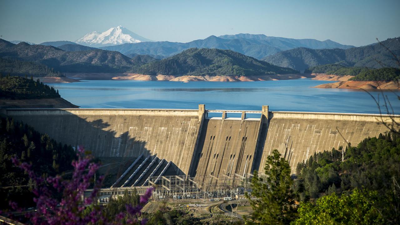 Aerial view of Shasta Dam with mountains in background