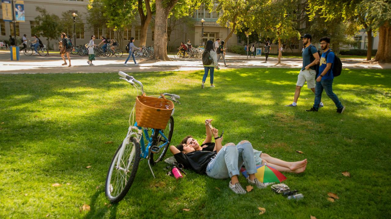 Student On Grass Next to Bike