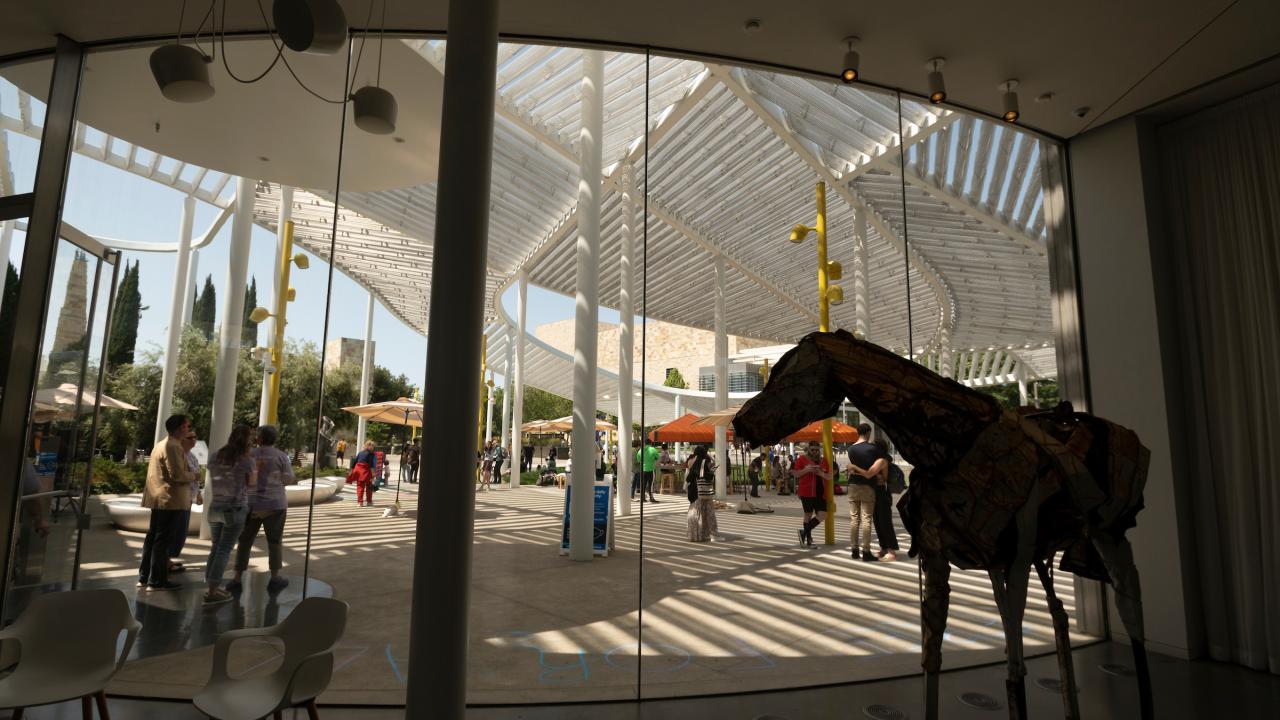 Photo taken from inside Manetti Shrem Museum of Art, with horse sculpture in shadow, looking out to Picnic Day Activities