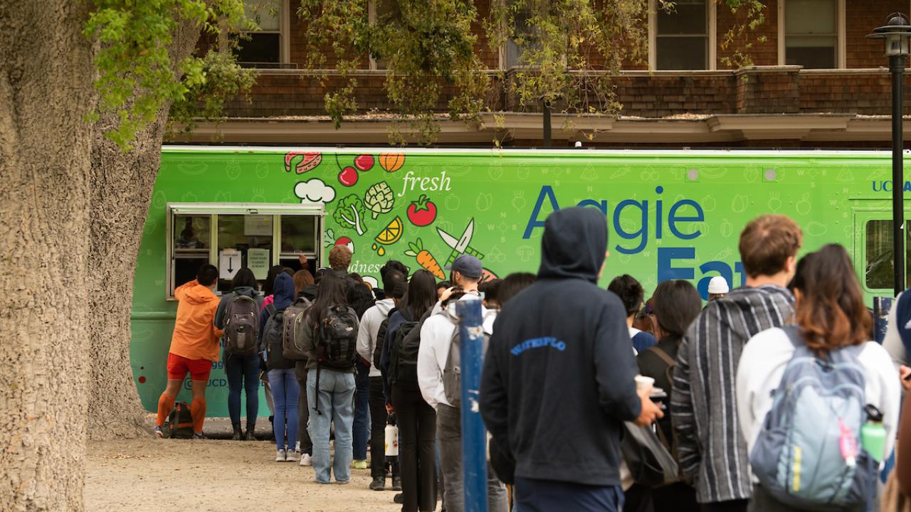 Students queue up for the bright green Aggie Eats food truck
