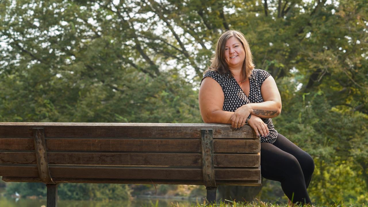 Katy Pattison smiles at a bench on the UC Davis campus. 