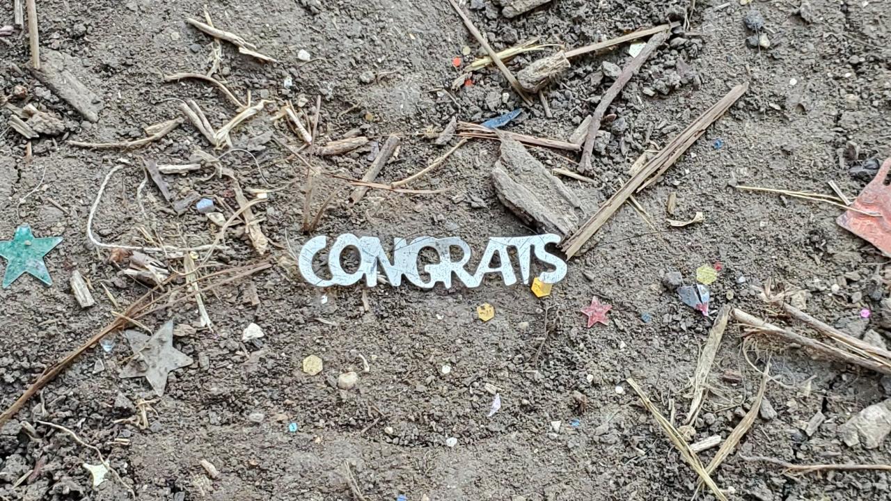 A "congrats" plastic cutout litters the ground