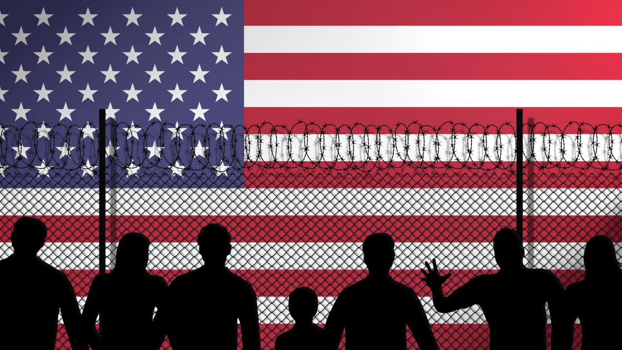 Image of American flag and immigrants on other side of fence