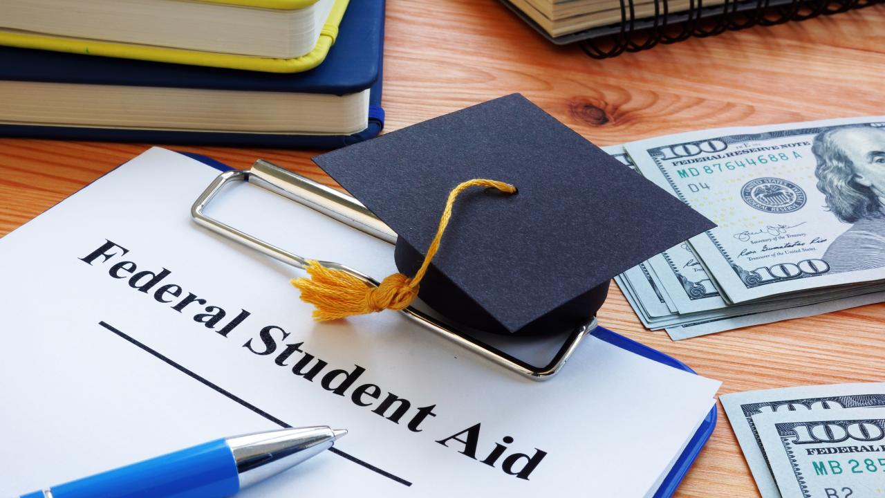 grad cap and student aid application and cash on desk for illustration