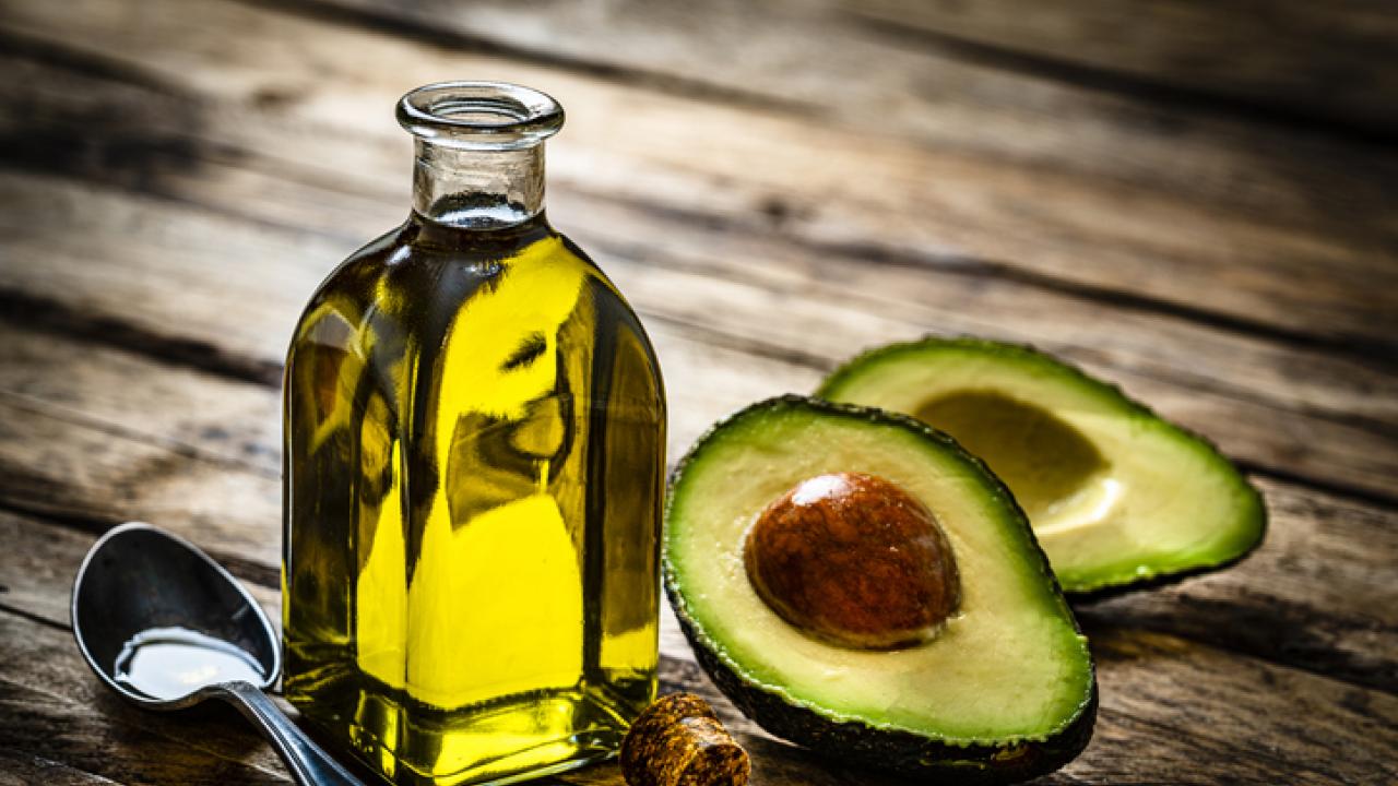 A UC Davis study finds most private label avocado oils are either rancid or adulterated. No enforceable standards for avocado oil exist yet. Pictured here is a bottle of avocado oil and spoon next to a cut avocado. (Getty Images)