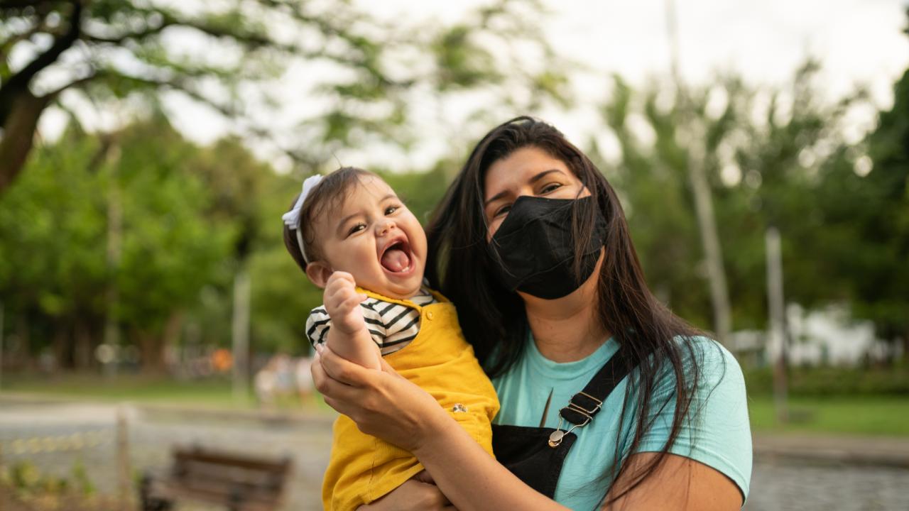 baby and masked mother in park setting