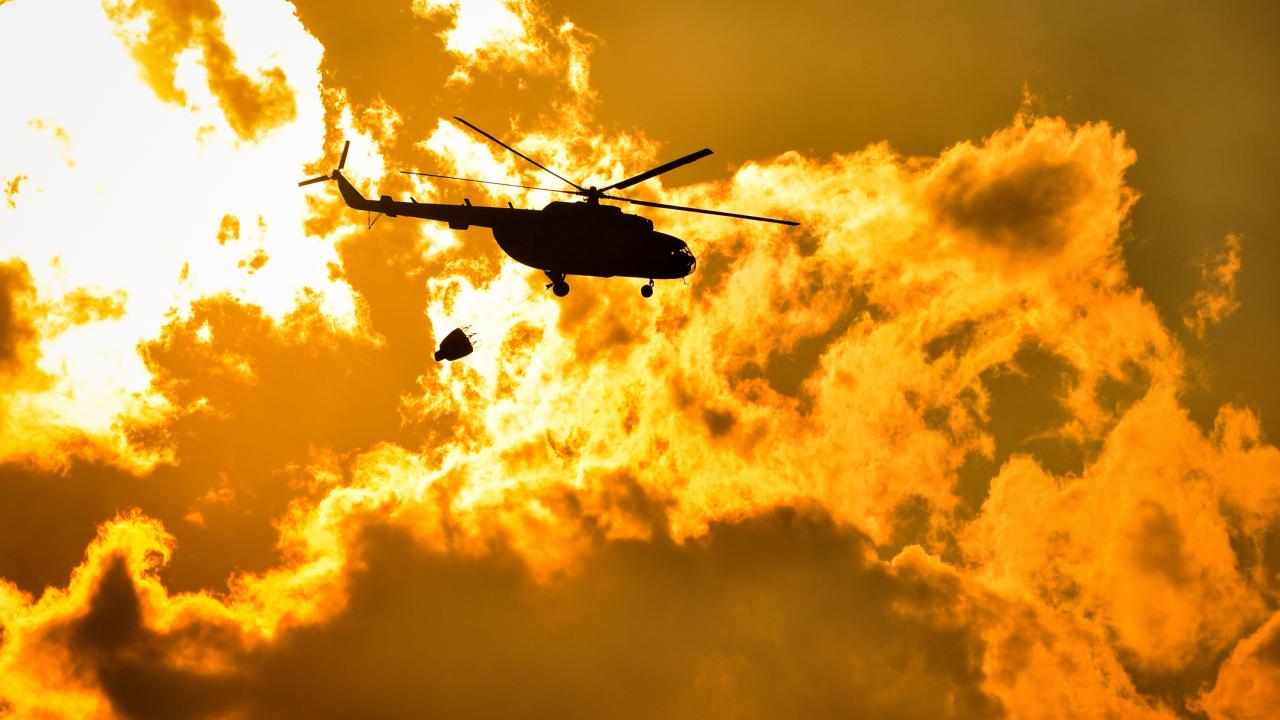Helicopter flies into burning fire
