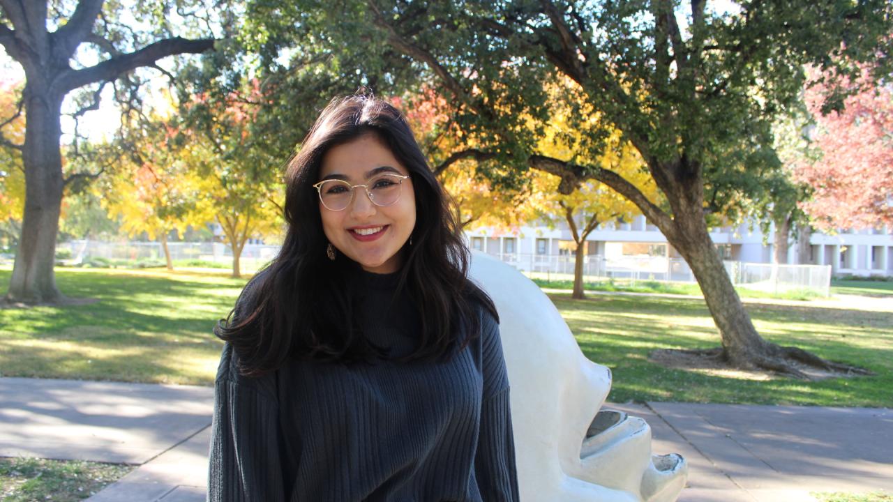 Donia Ghaith smiling in front of Mrak Hall on a sunny day.