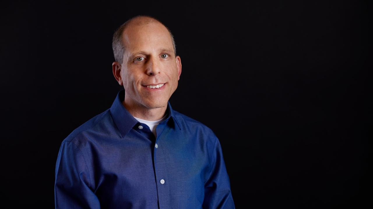 Man in a blue shirt with a black plain background