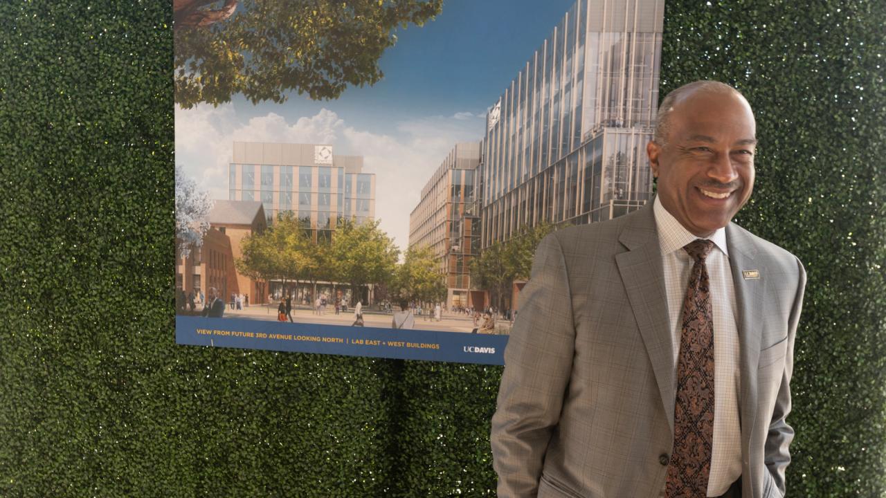 Gary S. May, casual, standing in front of Aggie Square rendering