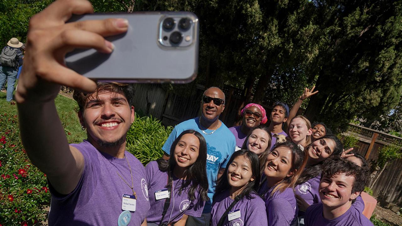Chancellor Gary S. May poses for selfie with students during Picnic Day.