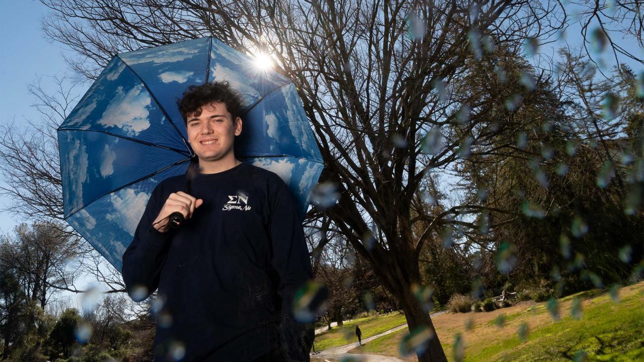 Man stands with umbrella outside