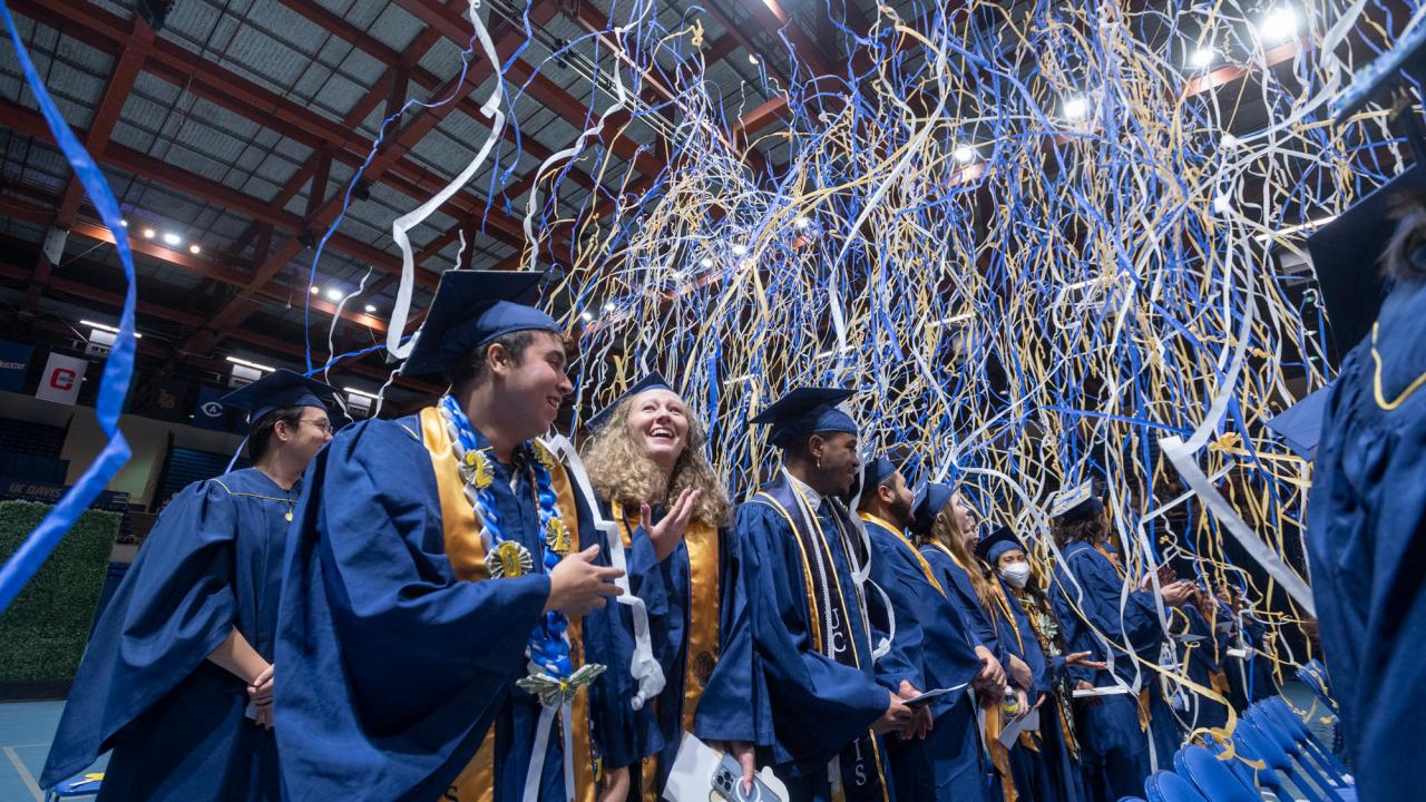 Blue and gold streamers fall upon graduates at commencement
