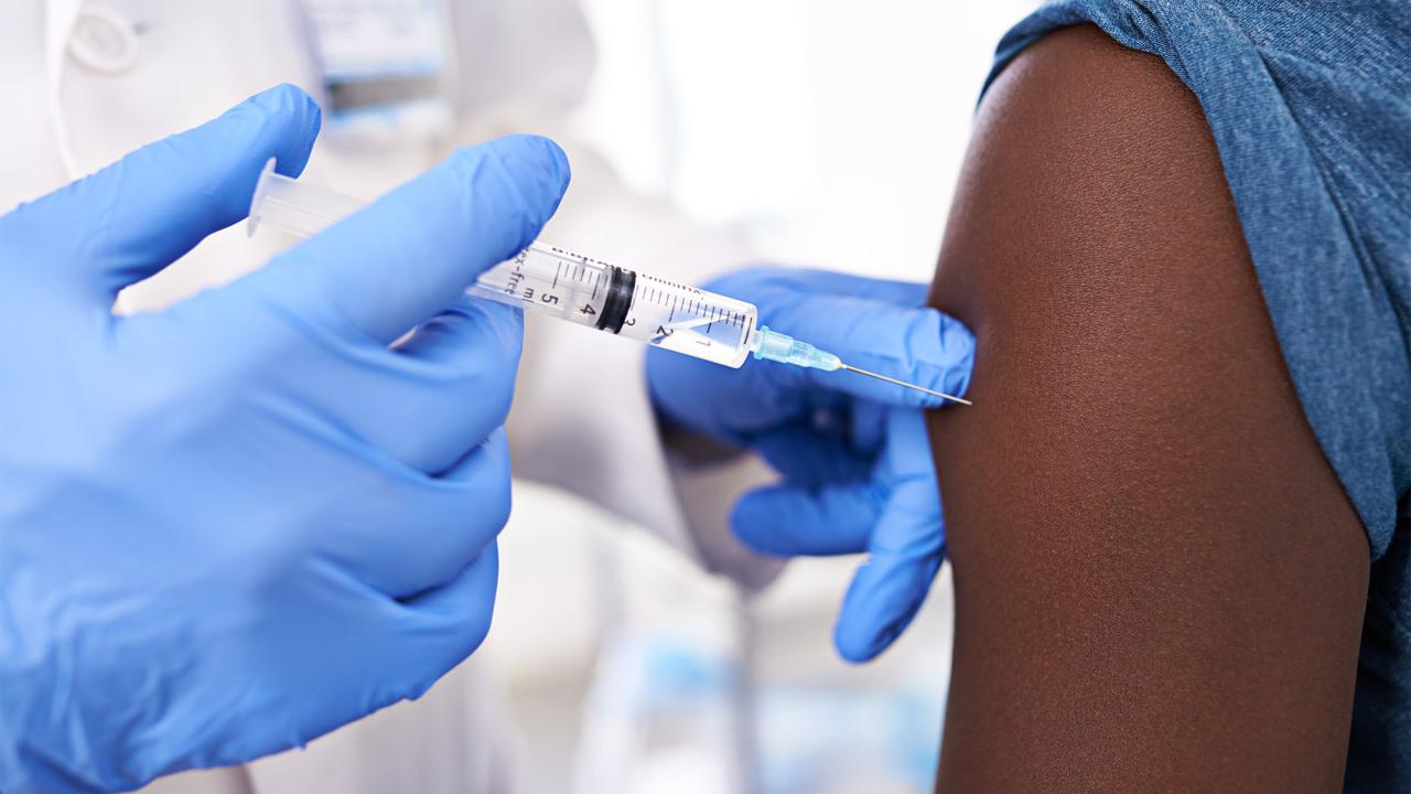 Person wearing gloves administers flu shot